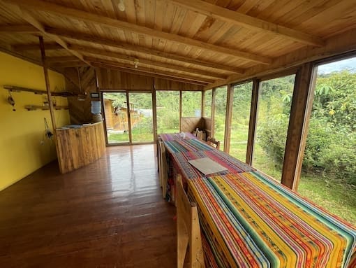 The Tamiaju dining room with colorful tablecloths and big windows looking into the forest