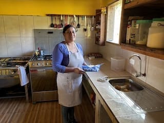 Monica, our cook at Cabañas Tamiaju, standing in the kitchen holding a tray.